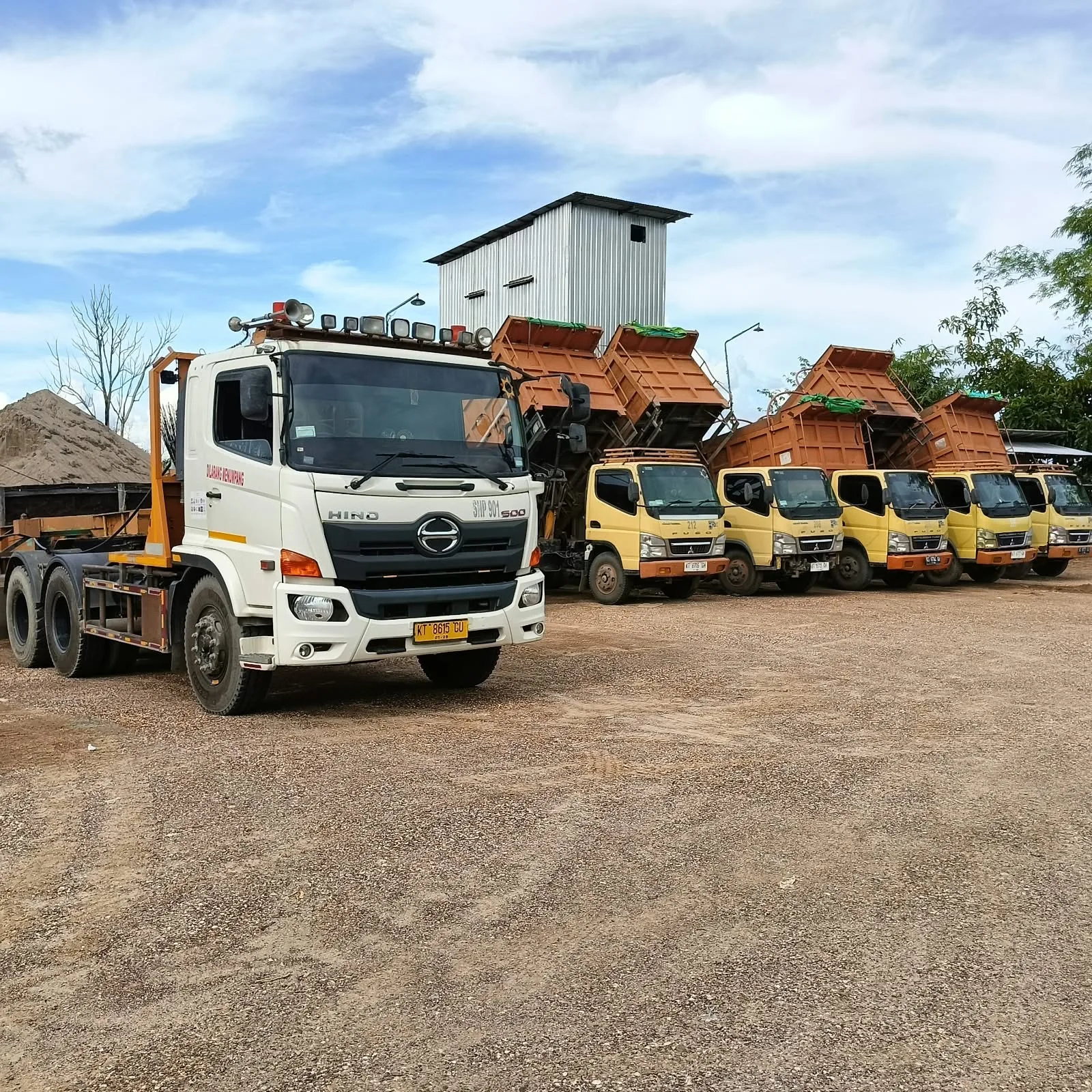 Dokumentasi kepala truk dan deretan dump truck di area parkir.