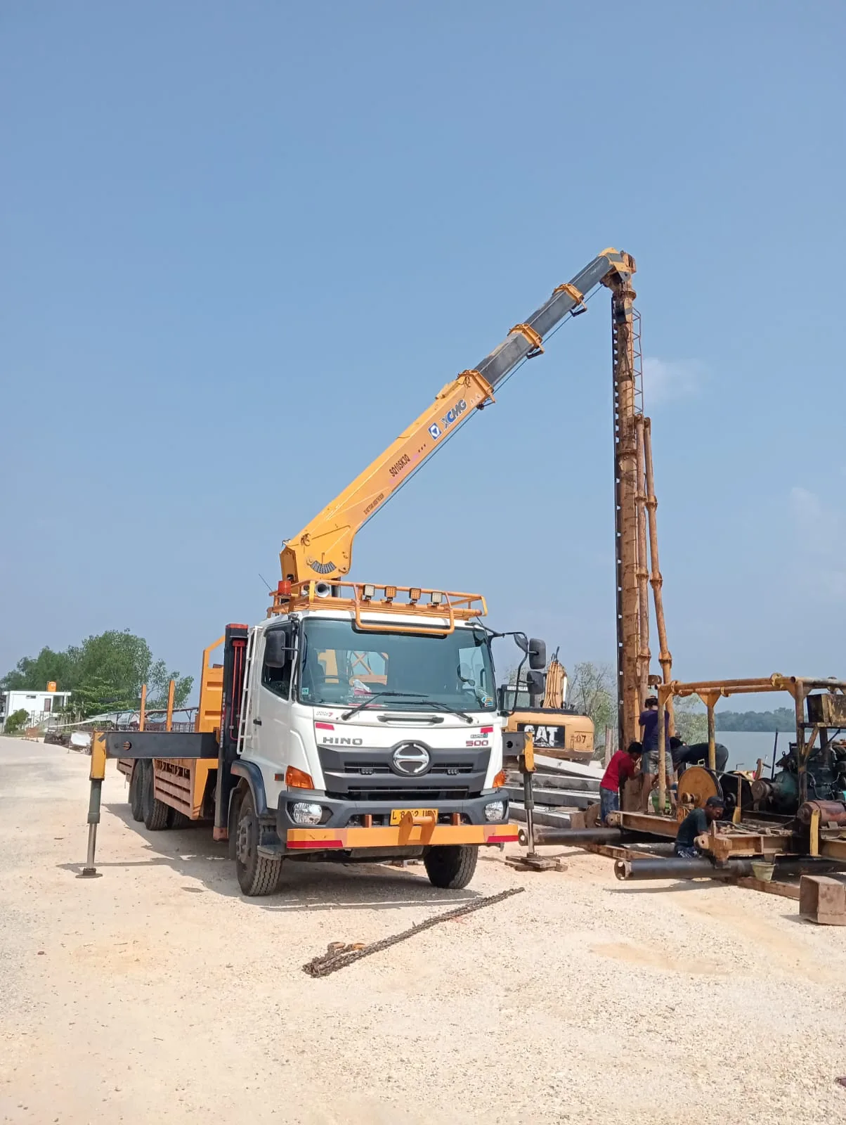 Truk dengan crane sedang menangani peralatan di lapangan